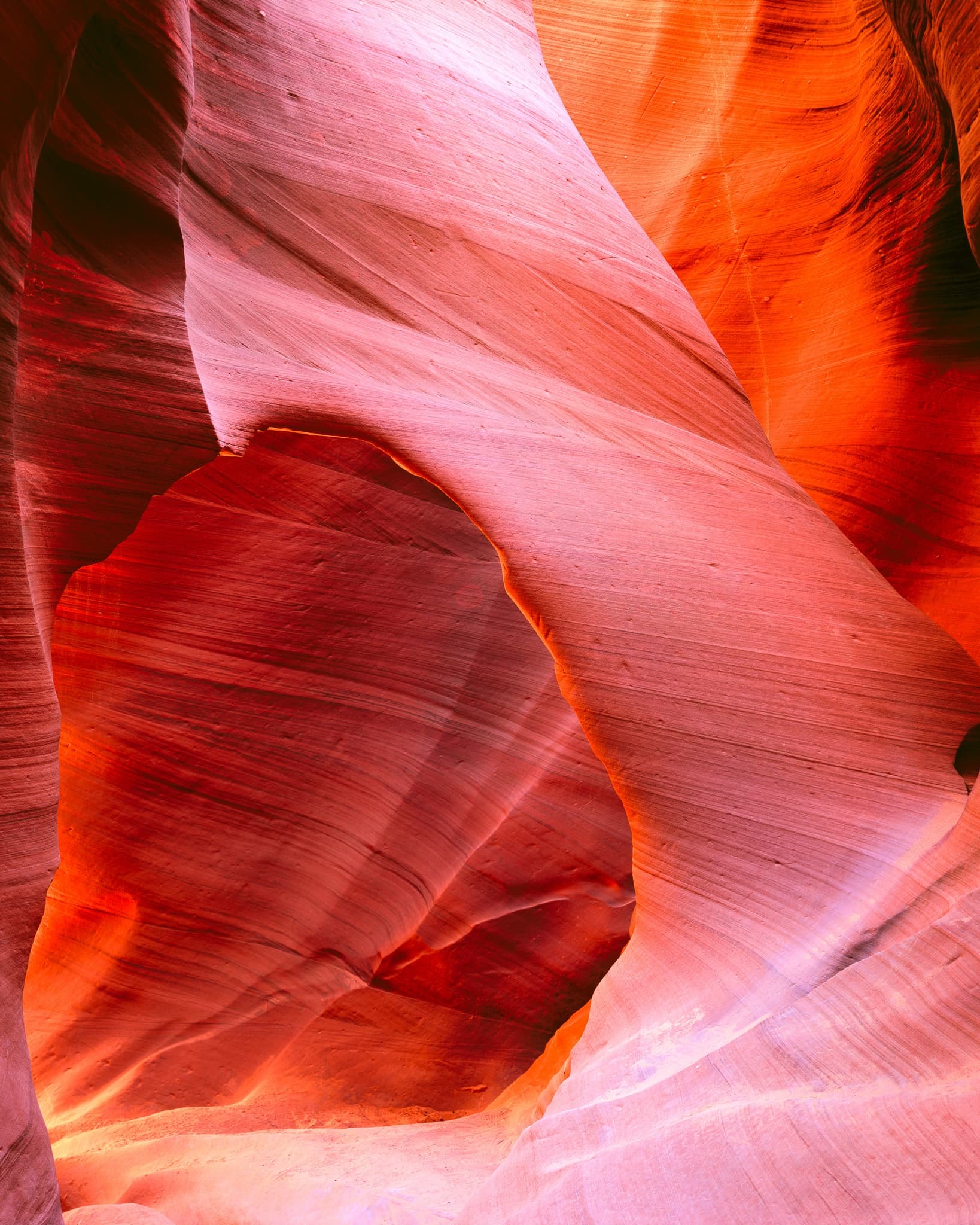 Inside Lower Antelope Canyon, an arch of sandstone frames the passage beyond, Arizona. Photograph by Marty Quinn