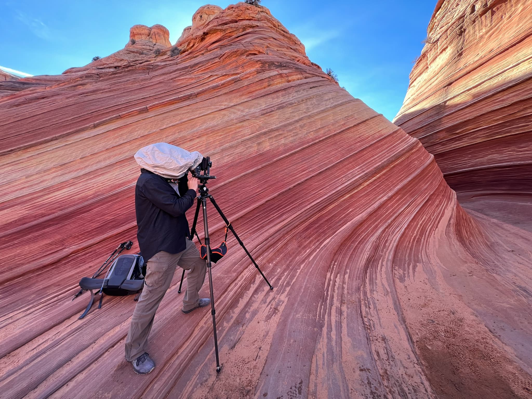Marty Quinn composing a shot under the dark cloth with his 4x5 large format camera at The Wave, Arizona