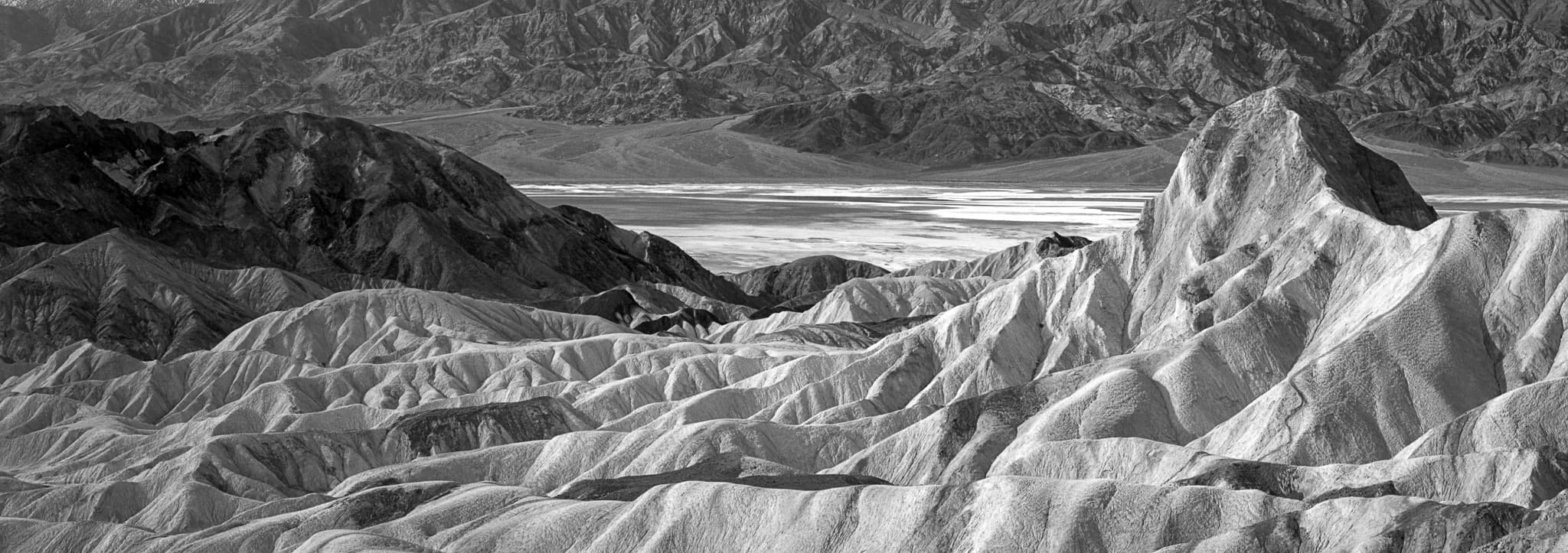 Zabriskie Point before dawn, when the badlands are pale and the light has no color yet, California. Photograph by Marty Quinn