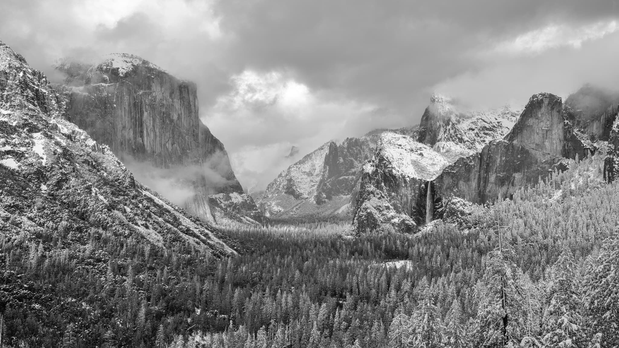 Yosemite Valley from Tunnel View just after a winter snowstorm — El Capitan and Half Dome in a clearing atmosphere, the valley floor in snow, California. Photograph by Marty Quinn