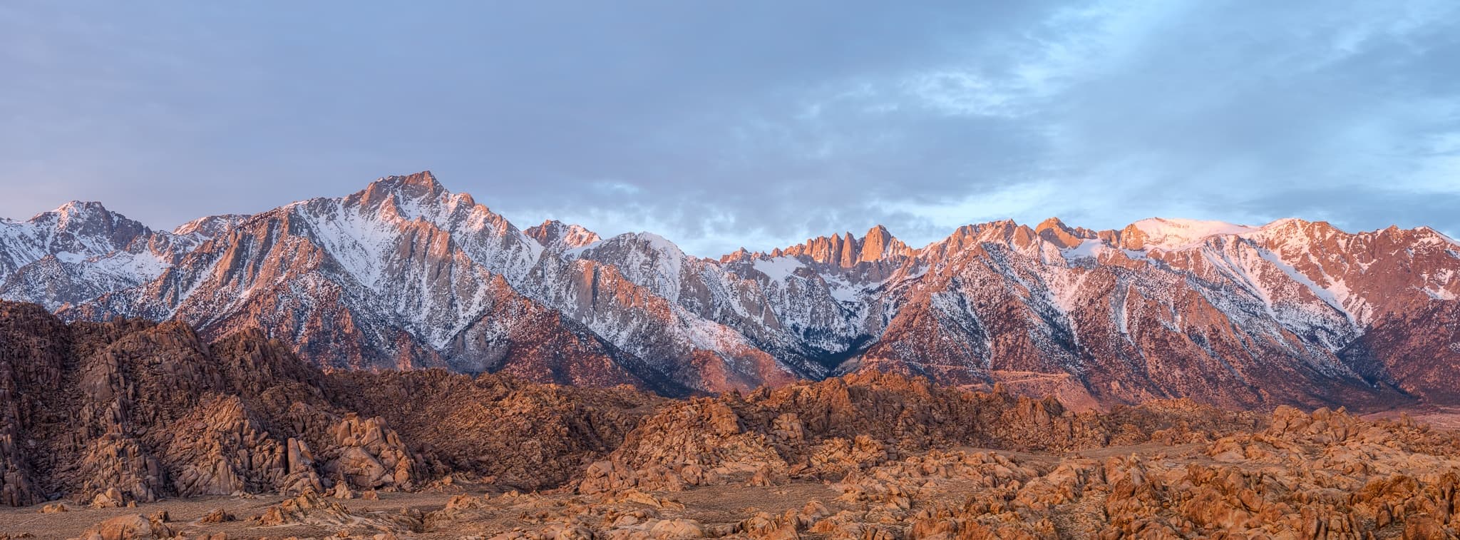The full sweep of the Sierra Nevada in winter — California's highest peaks in panoramic format, morning light on the snow. Photograph by Marty Quinn
